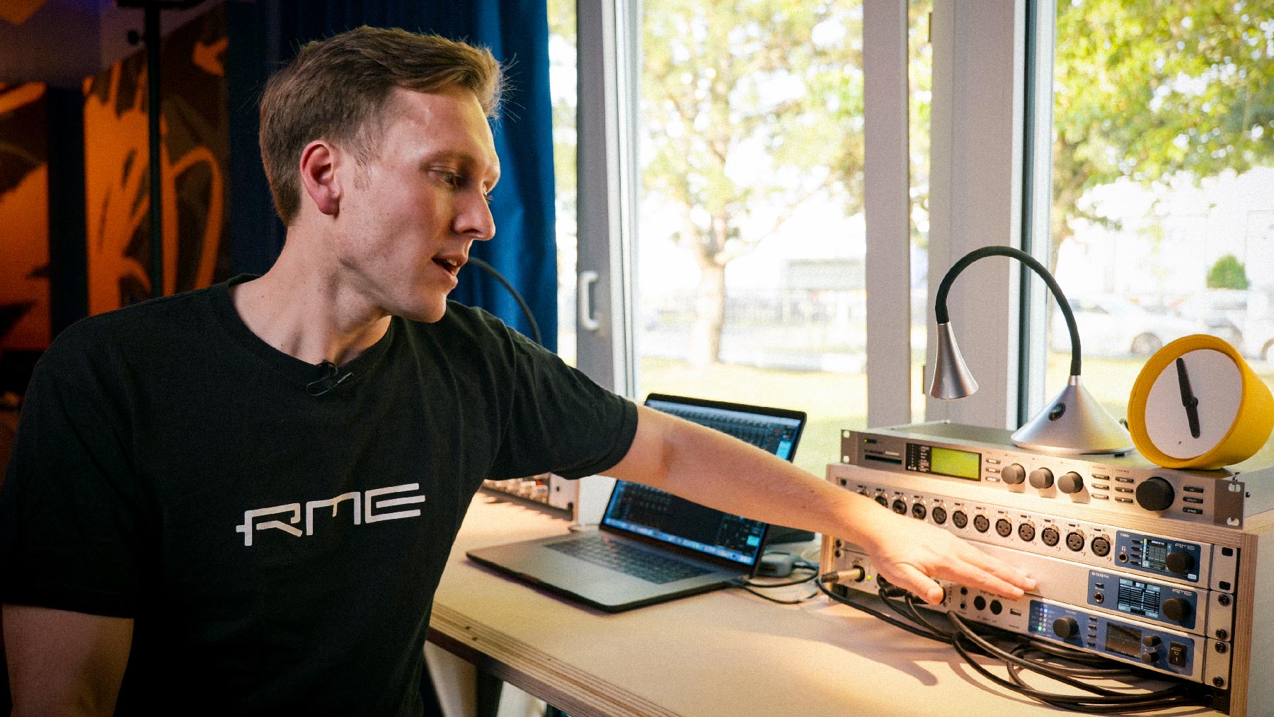 Marc Shettke of RME pointing to a rack of RME AVB equipment